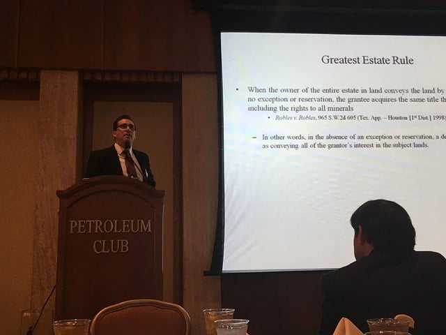 man standing at podium by screen during luncheon